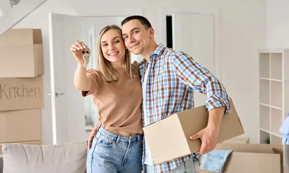 Pareja colombiana sonriente mostrando las llaves de su vivienda